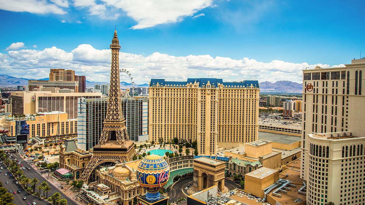 Wide shot from the sky of the Las Vegas Eiffel Tower and the surrounding attractions and businesses with a blue sky in Las Vegas, Nevada